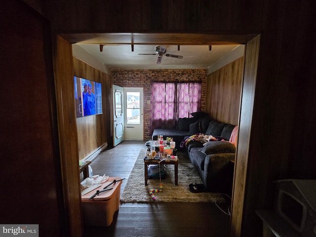 living room featuring a ceiling fan, wood walls, and hardwood / wood-style floors