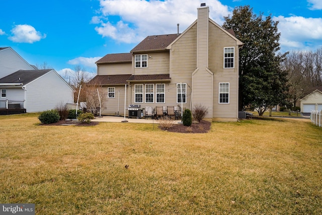 back of house featuring a yard, cooling unit, a patio, and a chimney