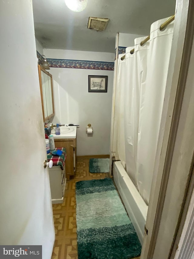 bathroom with shower / bath combo and vanity