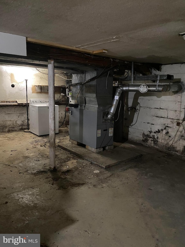 unfinished below grade area featuring heating unit, washer / clothes dryer, and a textured ceiling