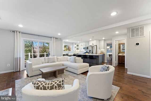 living room with dark wood-type flooring, recessed lighting, and visible vents