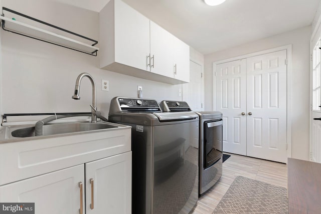 laundry area with washer and dryer, cabinet space, and a sink