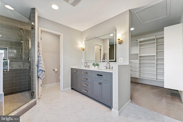 bathroom with marble finish floor, a shower stall, baseboards, and a sink