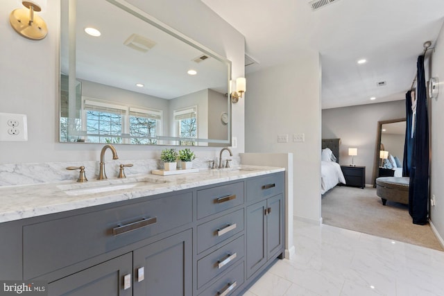 ensuite bathroom featuring marble finish floor, connected bathroom, a sink, and recessed lighting