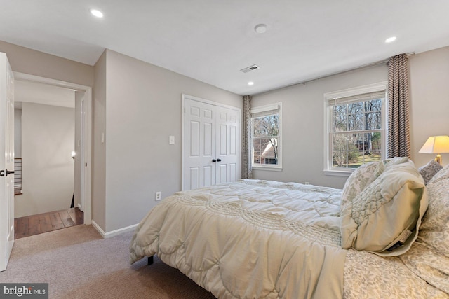 carpeted bedroom with baseboards, a closet, visible vents, and recessed lighting