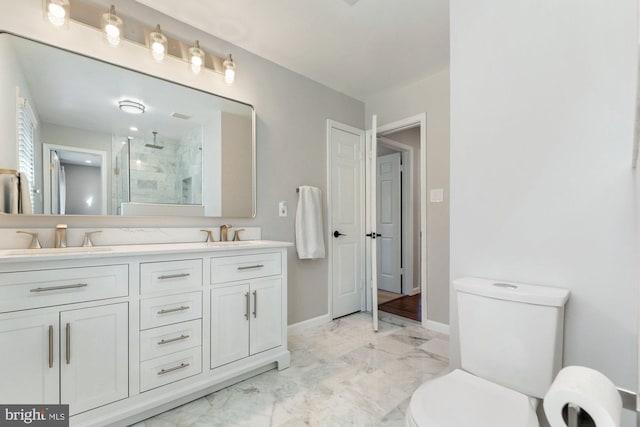 full bathroom with marble finish floor, a sink, a shower stall, and toilet