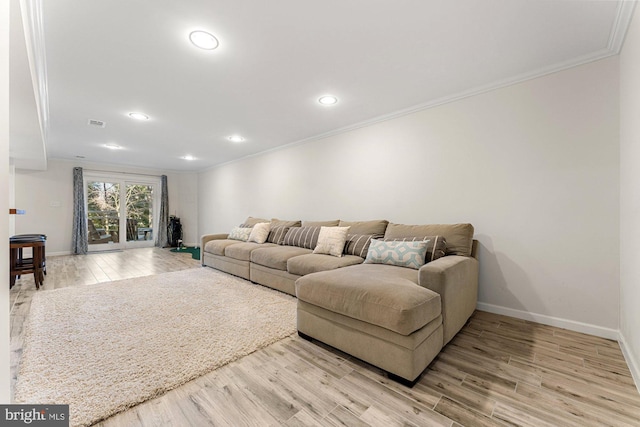 living area with light wood finished floors, ornamental molding, and baseboards