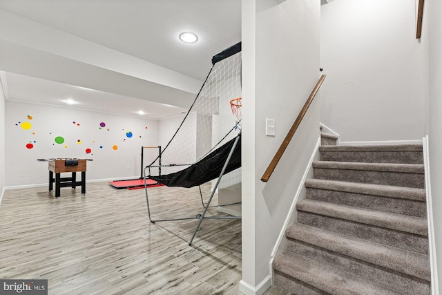 staircase with baseboards and wood finished floors