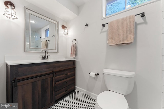 bathroom with toilet, vanity, baseboards, and tile patterned floors