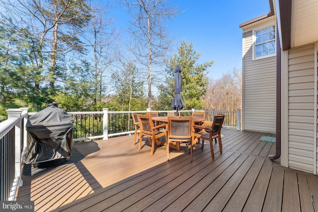 wooden deck featuring outdoor dining space and a grill