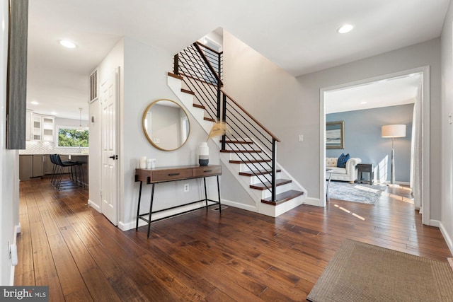 entrance foyer featuring stairs, hardwood / wood-style floors, visible vents, and baseboards