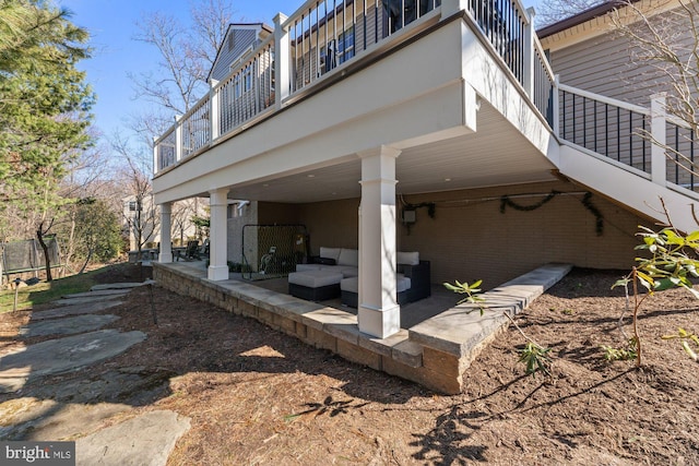 view of property exterior with brick siding, a patio, and a balcony