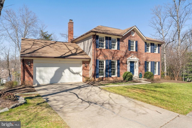 colonial-style house featuring a garage, concrete driveway, brick siding, and a chimney