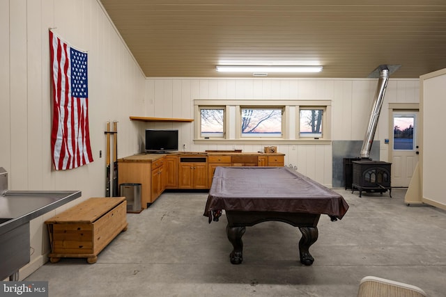 recreation room featuring a wood stove, concrete flooring, and pool table