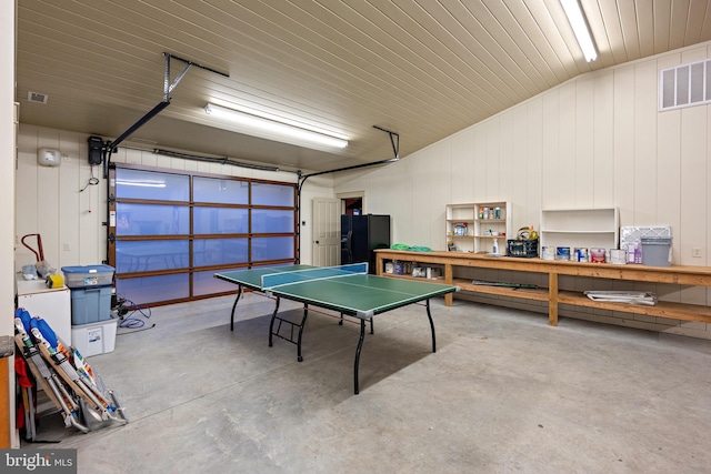 garage with visible vents and black refrigerator with ice dispenser