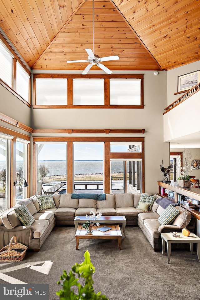 carpeted living room featuring a high ceiling, a water view, and wood ceiling