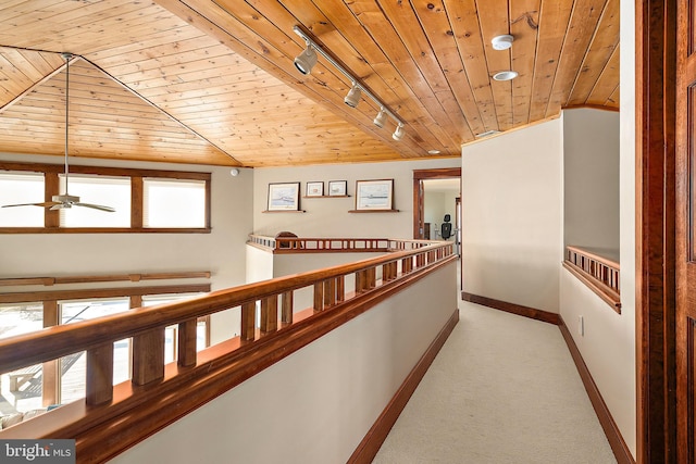 hallway with light colored carpet, wood ceiling, baseboards, vaulted ceiling, and an upstairs landing