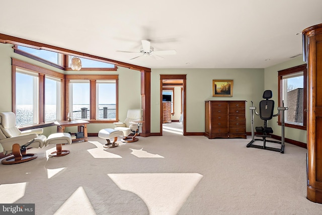 interior space with light carpet, ceiling fan, and baseboards