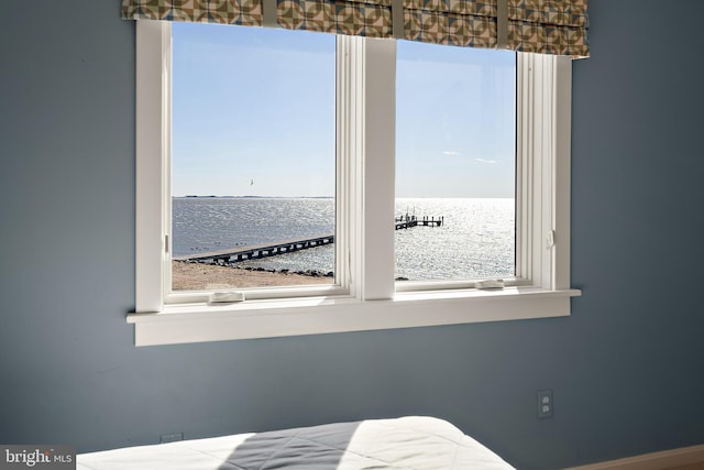 unfurnished bedroom featuring a water view and multiple windows