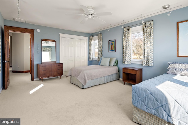 carpeted bedroom with a closet, visible vents, ceiling fan, and baseboards