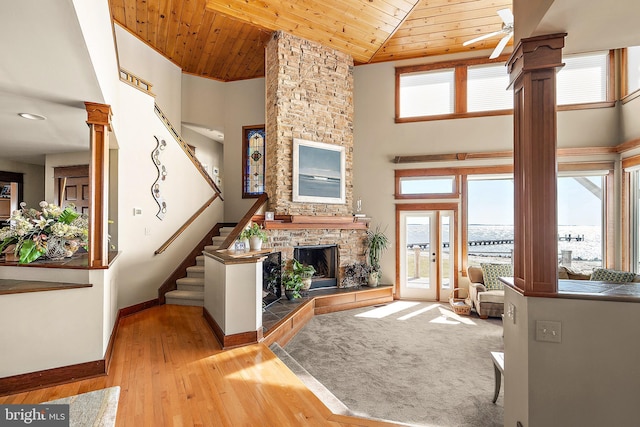 living room with a wealth of natural light, wood ceiling, a fireplace, and baseboards