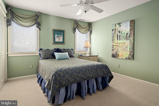 carpeted bedroom featuring a ceiling fan, visible vents, and baseboards