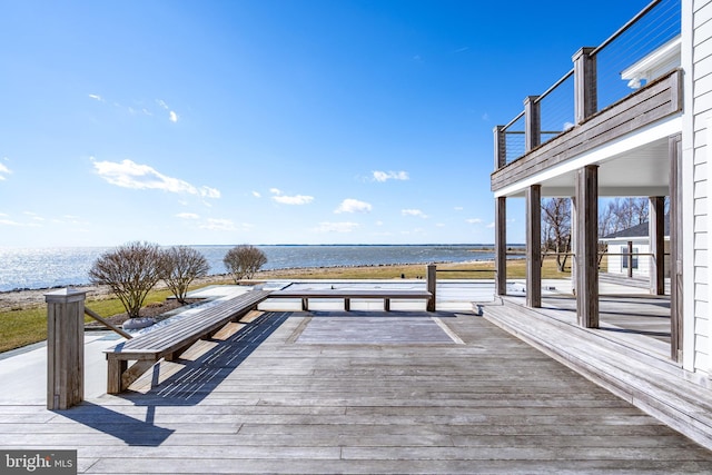 wooden terrace featuring a water view and a beach view