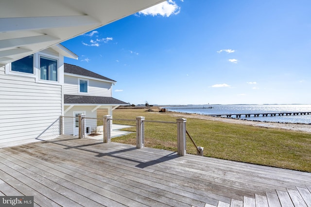 wooden deck featuring a yard, a water view, and a beach view