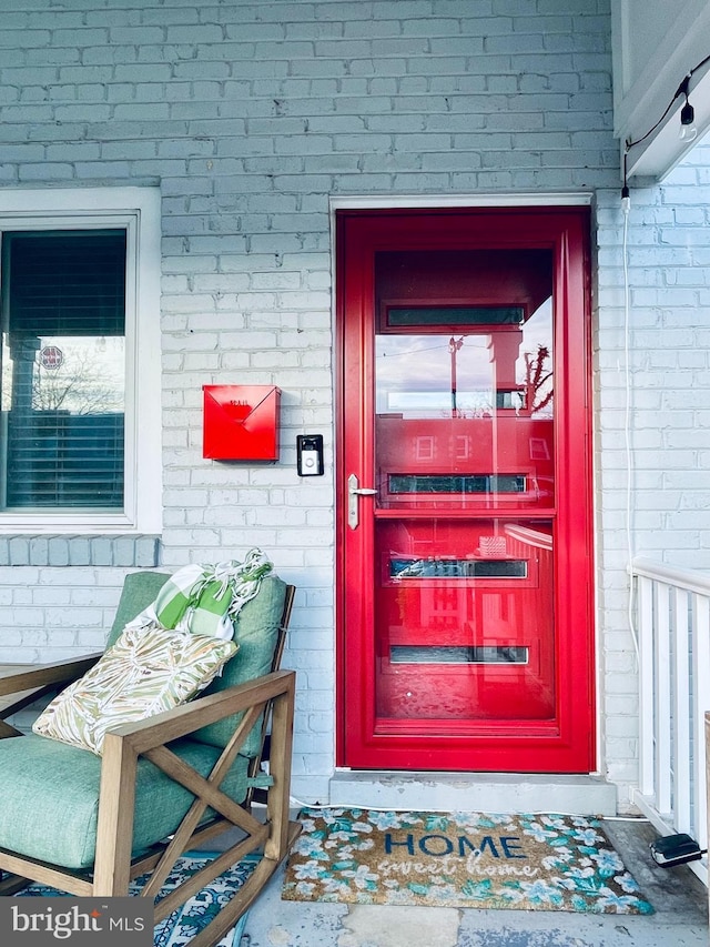 view of exterior entry featuring brick siding