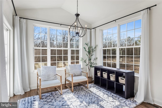 sunroom / solarium with a chandelier, a healthy amount of sunlight, vaulted ceiling, and visible vents