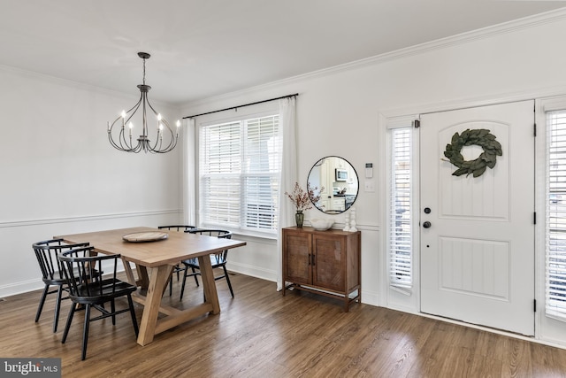 dining area featuring baseboards, a notable chandelier, ornamental molding, and wood finished floors