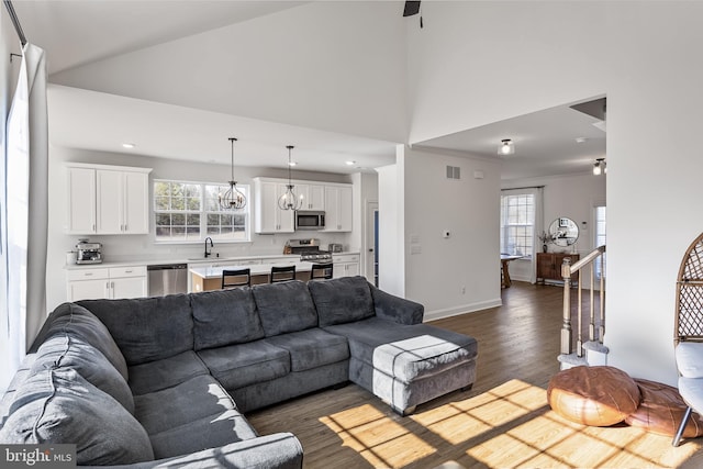 living room with visible vents, baseboards, dark wood-style floors, high vaulted ceiling, and recessed lighting