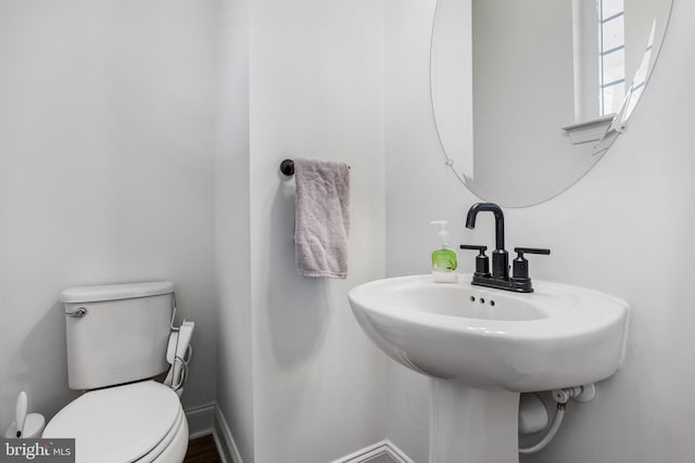 half bathroom with toilet and baseboards