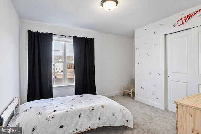 bedroom with light carpet, a closet, and baseboards