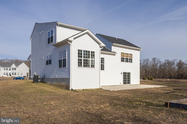 back of property with a yard, a patio area, and central air condition unit