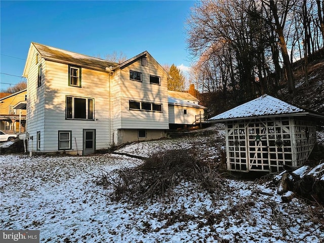 view of snow covered rear of property