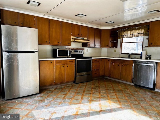 kitchen with light floors, appliances with stainless steel finishes, light countertops, and under cabinet range hood