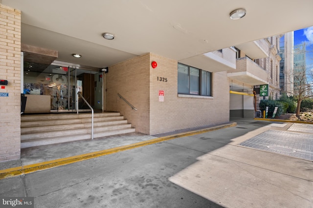 entrance to property featuring brick siding