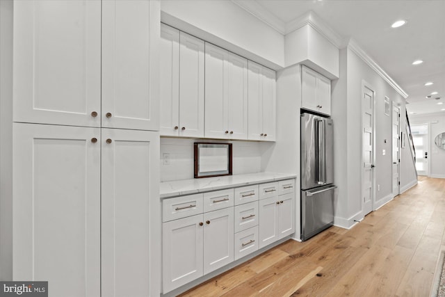 kitchen with high quality fridge, recessed lighting, white cabinets, and crown molding