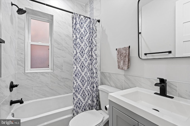 bathroom featuring vanity, shower / bath combo with shower curtain, toilet, and tile walls