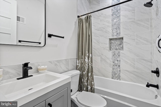 full bath with tile walls, visible vents, toilet, shower / tub combo, and vanity