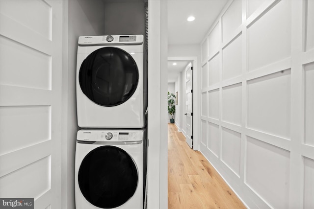 laundry area with laundry area, recessed lighting, light wood-style flooring, and stacked washer / drying machine