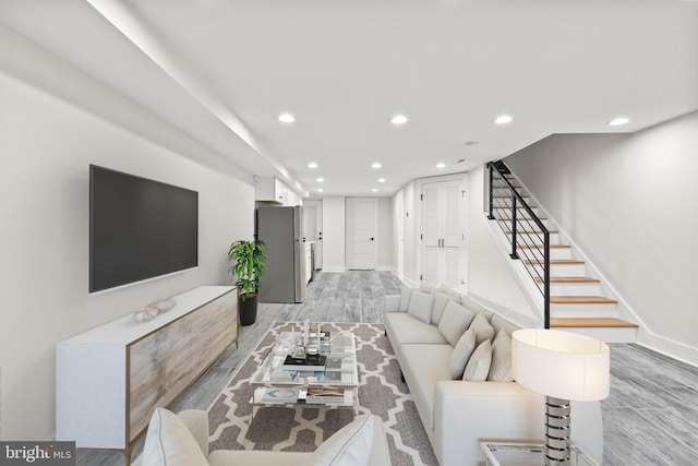 living area featuring light wood-type flooring, recessed lighting, baseboards, and stairs