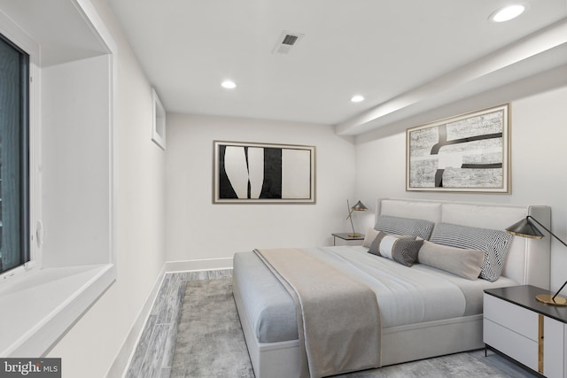 bedroom with recessed lighting, visible vents, baseboards, and wood finished floors