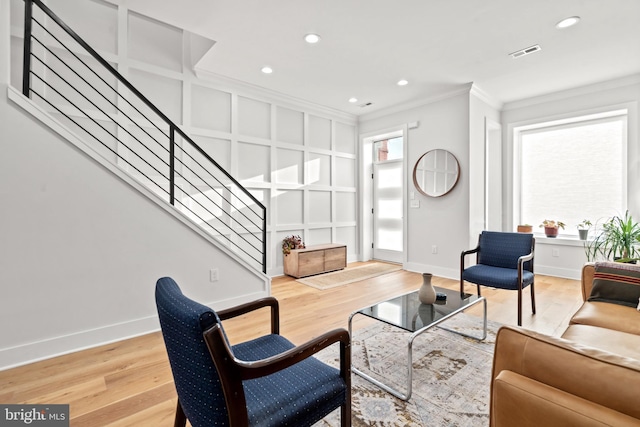 living room featuring crown molding, visible vents, stairway, light wood-style flooring, and baseboards