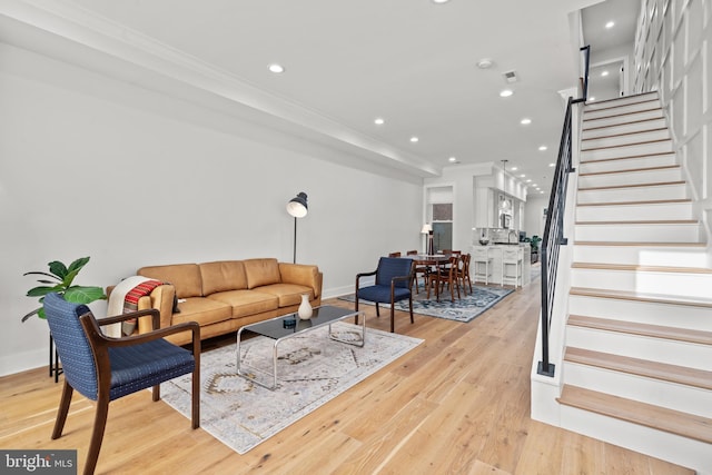 living area with light wood-style flooring, stairs, crown molding, and recessed lighting