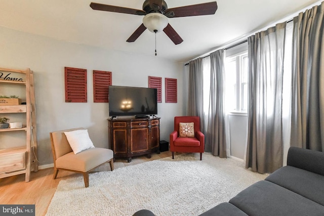 living area with ceiling fan, wood finished floors, and baseboards