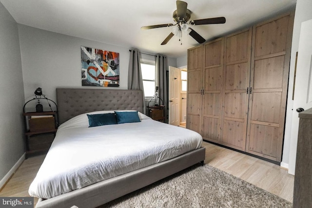 bedroom with ceiling fan, light wood-style flooring, and baseboards