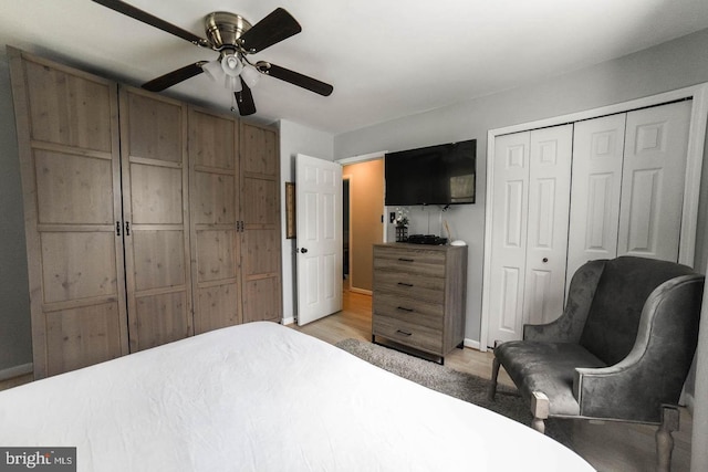 bedroom featuring a ceiling fan, a closet, light wood-style flooring, and baseboards