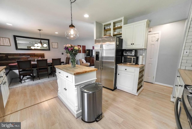 kitchen with white cabinets, light wood-type flooring, butcher block countertops, and stainless steel appliances